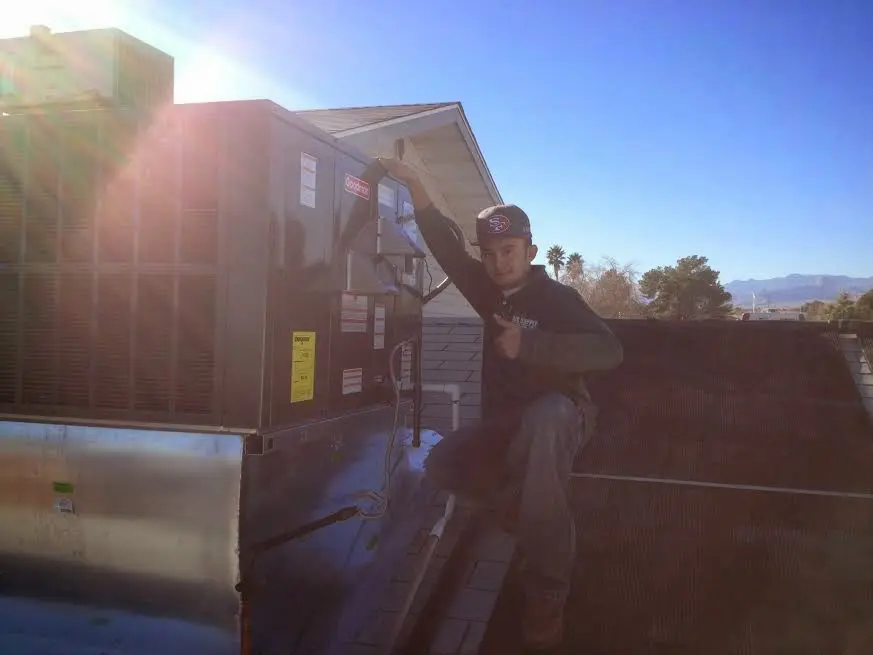 HVAC technician performing Heat Pump Repair on a rooftop unit in Walker Mill